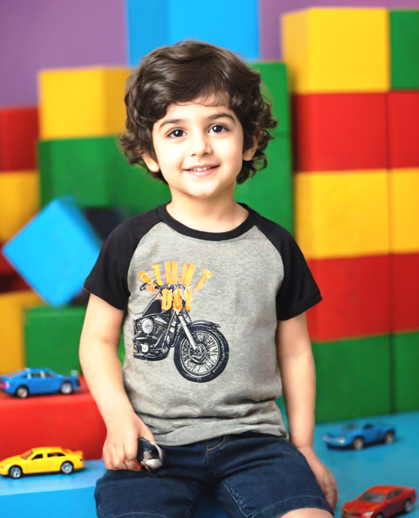 Young boy wearing a grey and navy Stunt Boy motorcycle graphic T-shirt