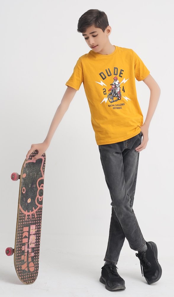 Boy wearing a mustard yellow Dude 24 cotton T-shirt while holding a skateboard