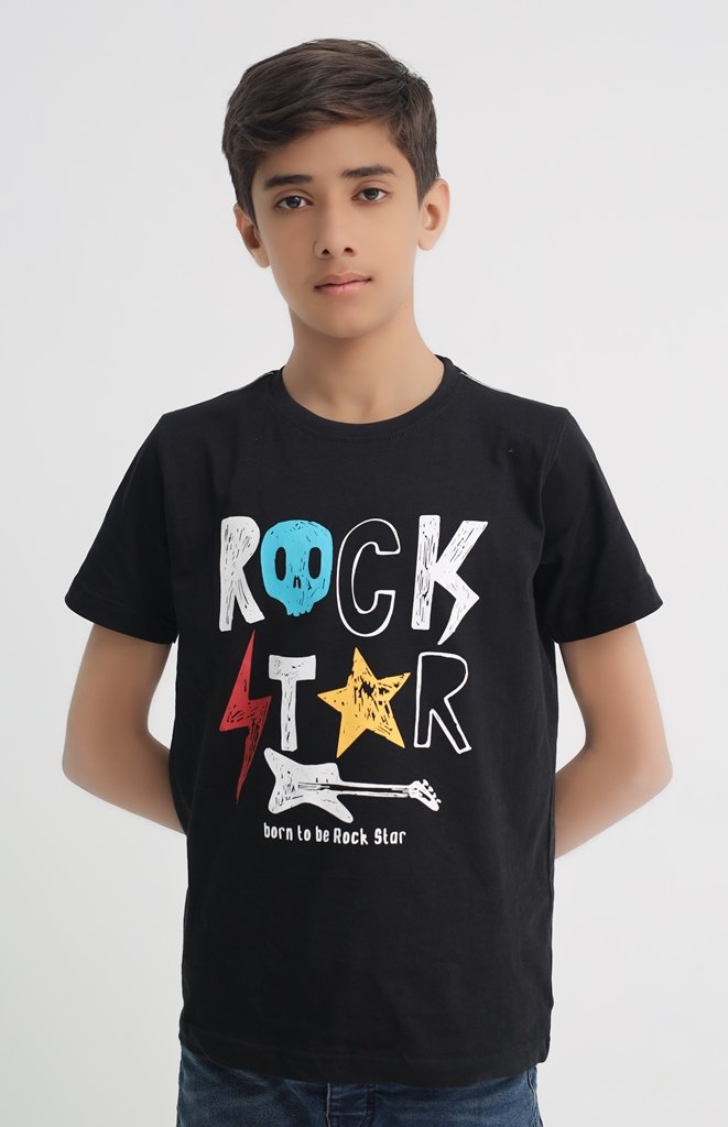 Front view of boy wearing a black Rock Star graphic T-shirt