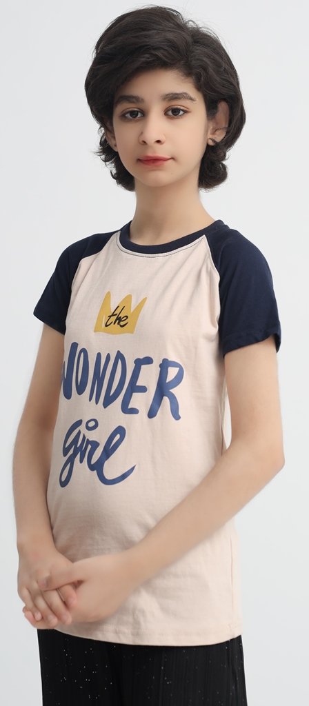 Girl wearing a beige and navy Wonder Girl graphic raglan T-shirt