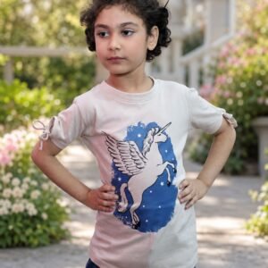 Girl wearing a light beige unicorn graphic T-shirt with tie sleeves