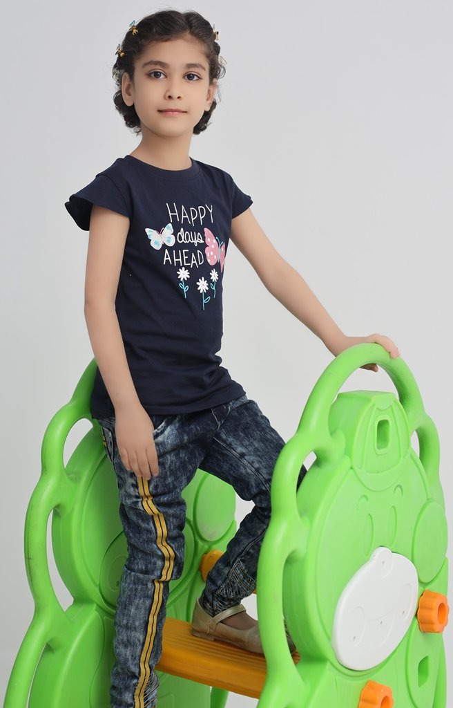 Girl wearing a navy blue butterfly T-shirt with jeans during playtime
